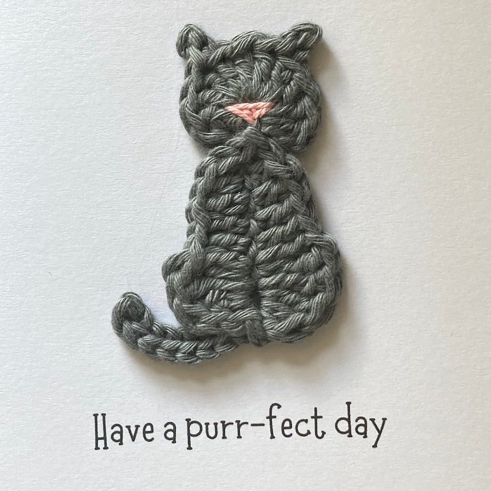 Blank square card with handmade grey cat crochet details close up